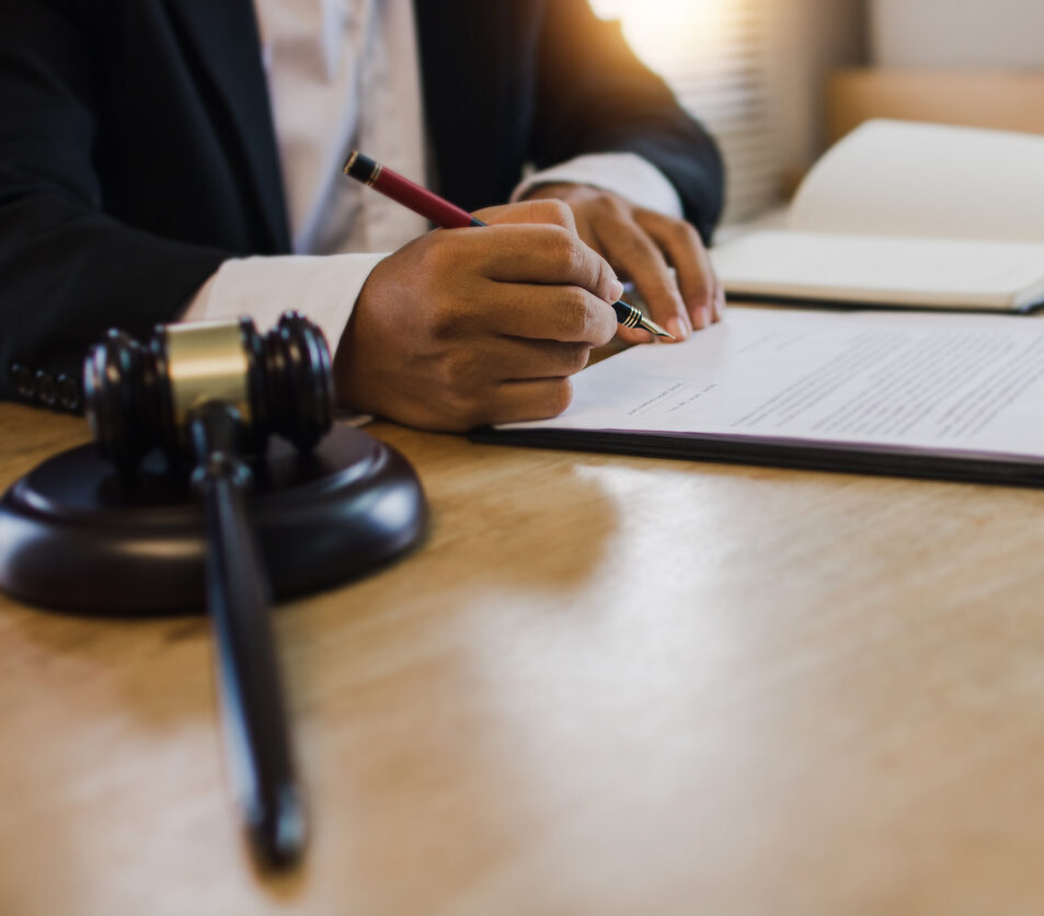 hand of business people sign contract with justice hummer on table