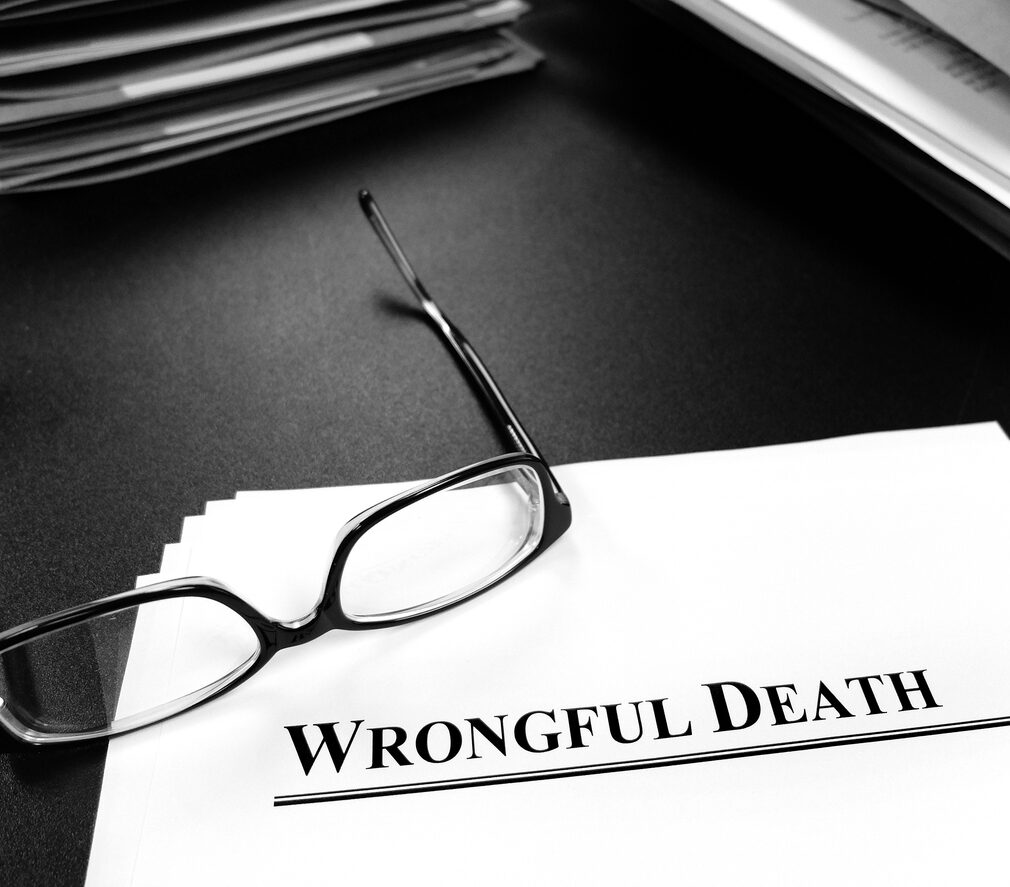 Wrongful death papers on desk with glasses for legal services or lawsuit