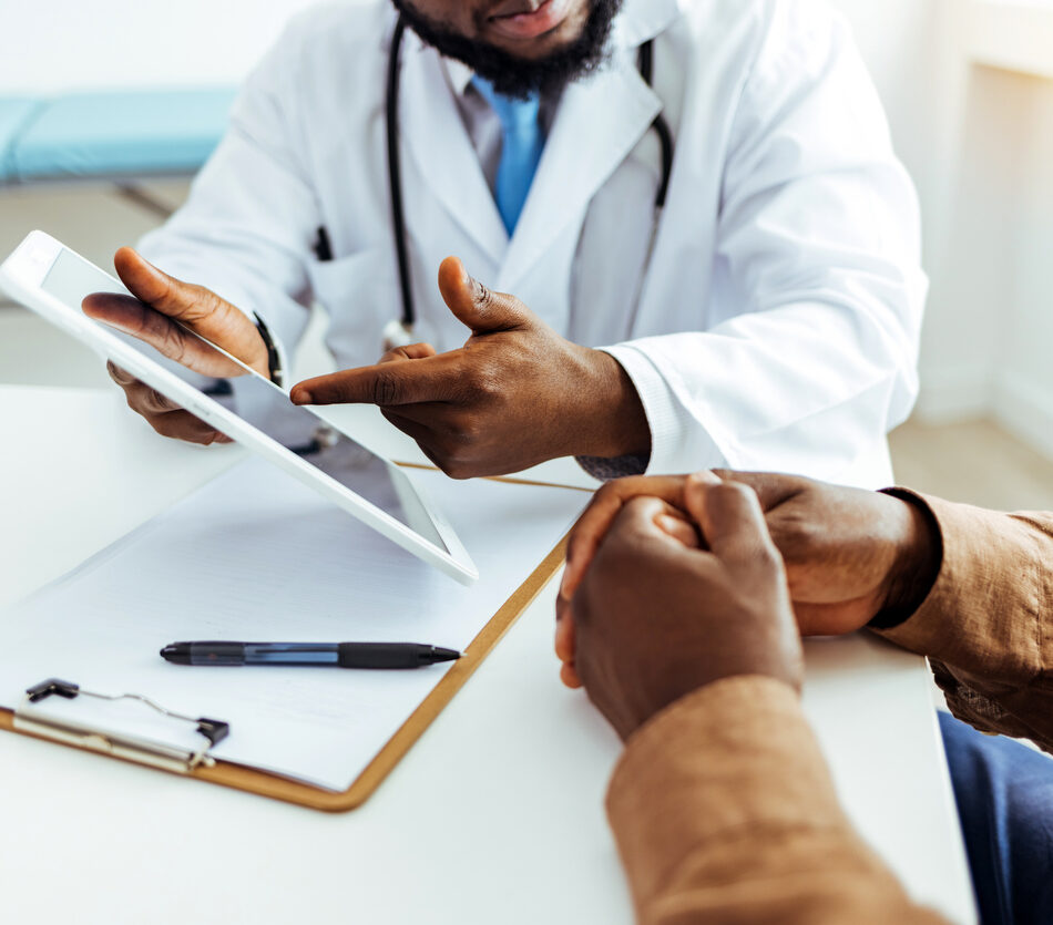 Friendly Male Doctor Talks to Sick Male Patient