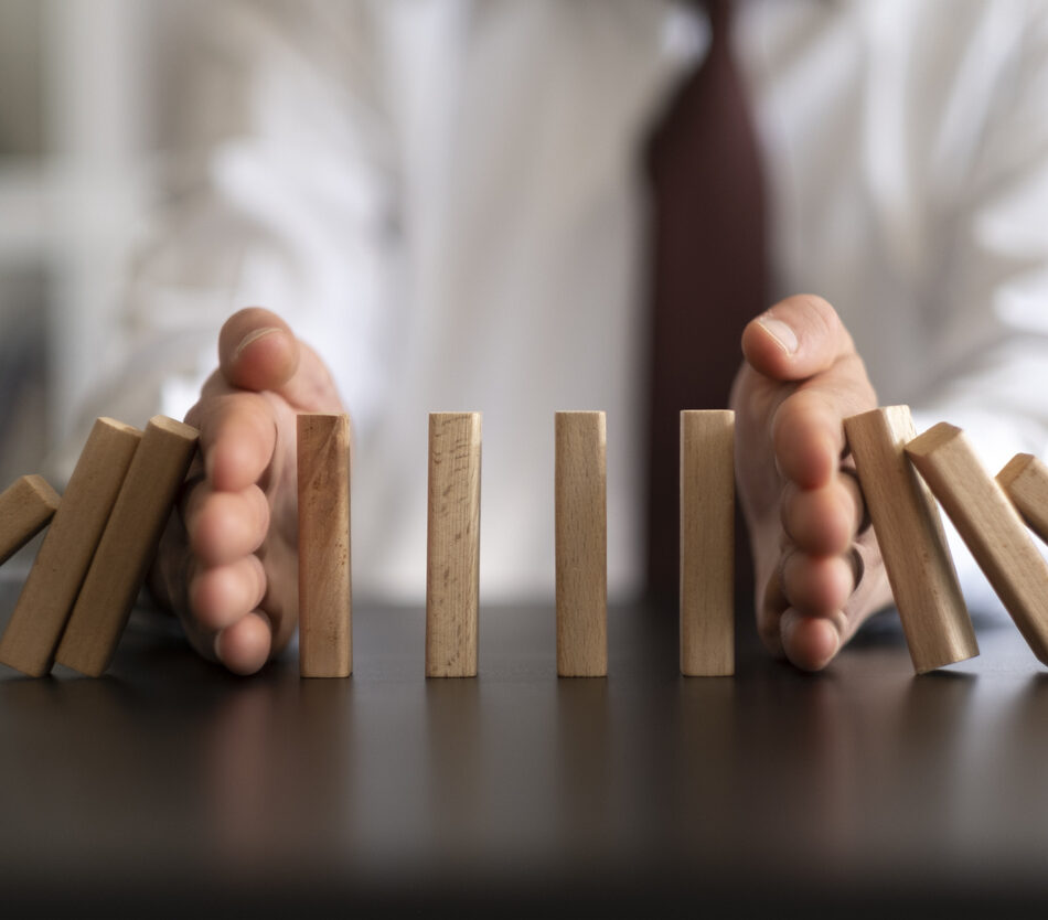 Businessman Stop Domino Effect. Risk Management and Insurance Concept