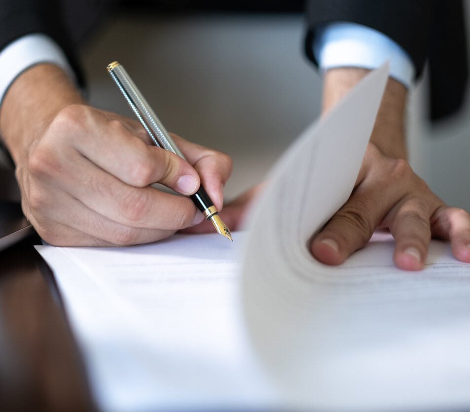 Close-up of hands of unknown businessman in suit signing official document