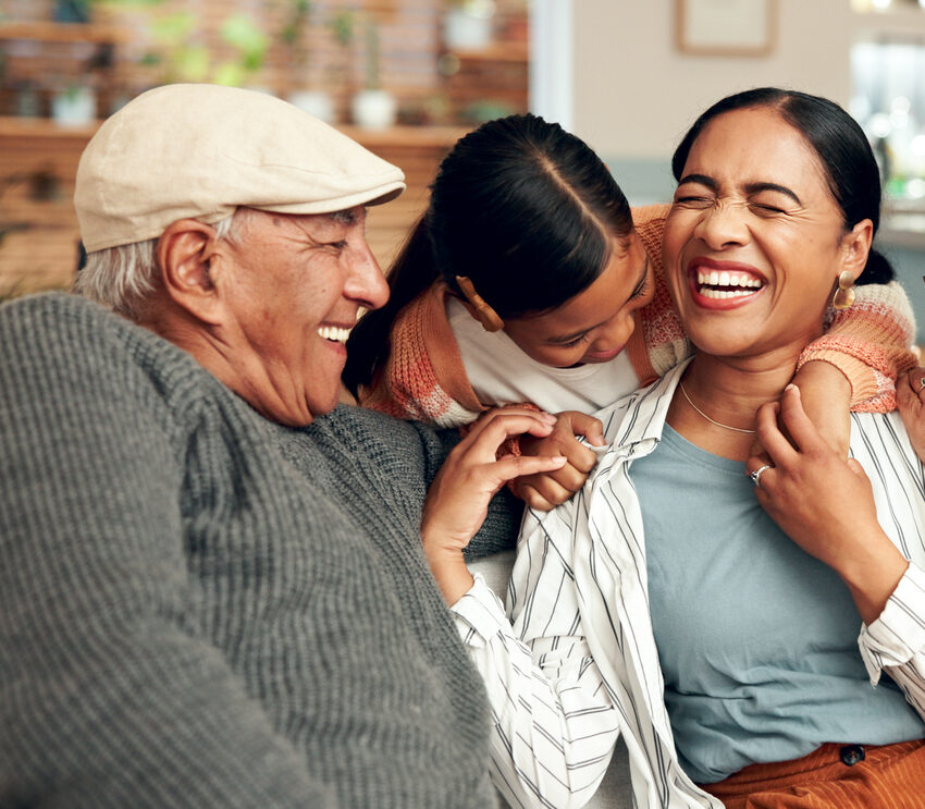 Happy family, hug and laugh on sofa for reunion, trust or support at home on weekend. Grandparents, love or woman with kid for bonding, excited or funny story telling from past memories or connection