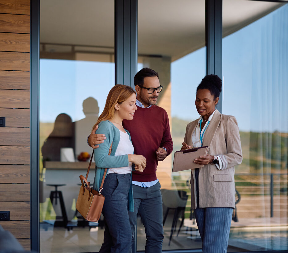 African American real estate agent going through housing plans with a couple who is buying a new home. Copy space.
